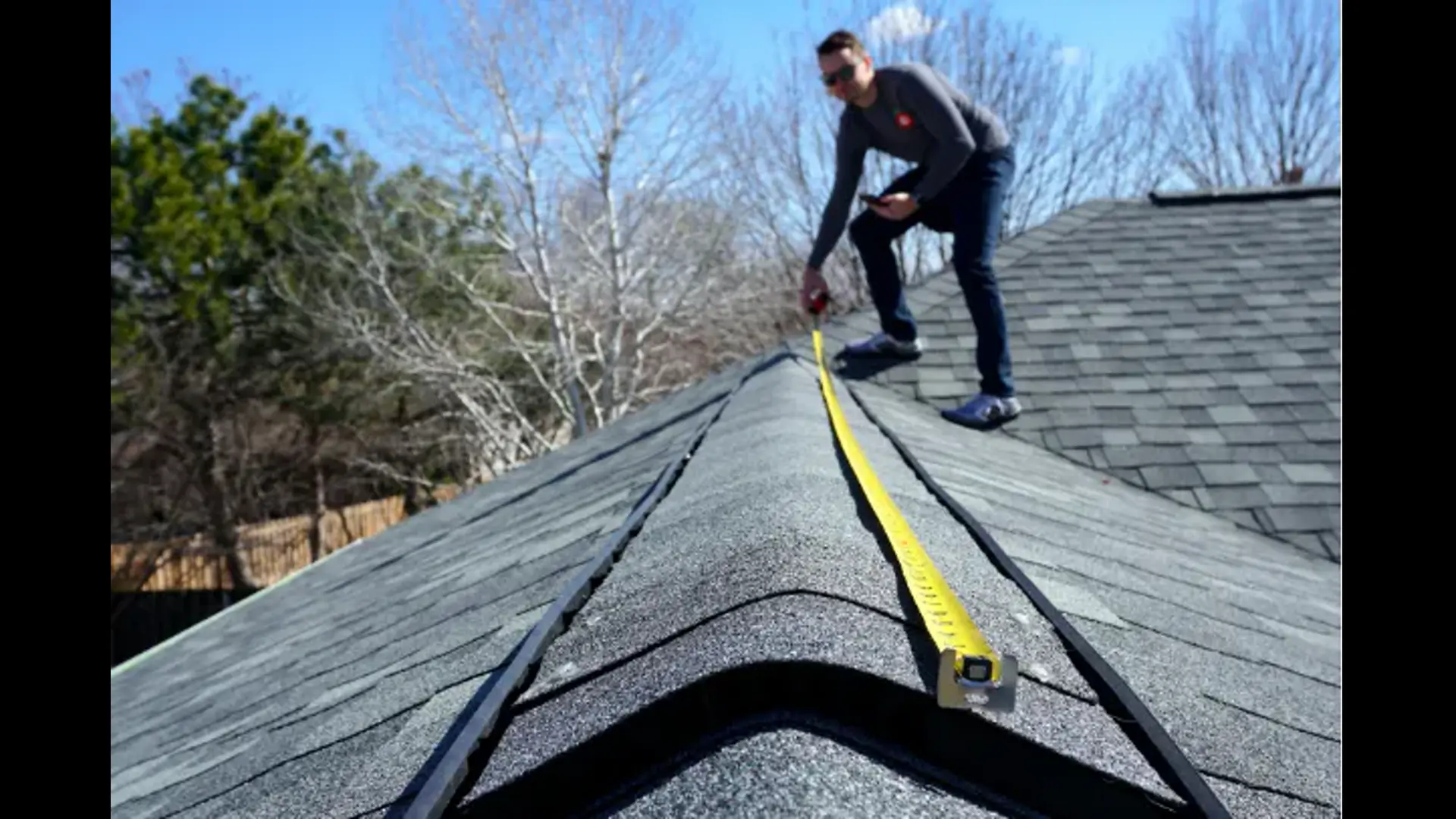 Roofer measuring a shingle roof